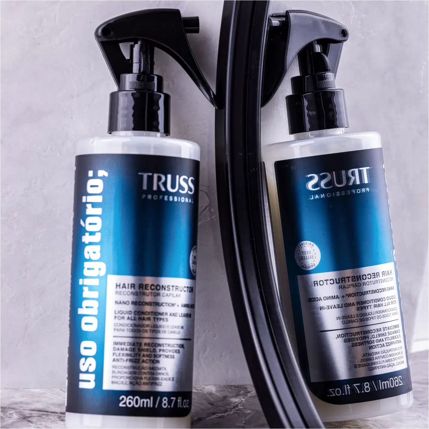 Produto de reconstrução capilar TRUSS Professional. Embalagem plástica transparente com spray acionado por bomba. Cor predominante azul escuro na parte central com detalhes em branco.