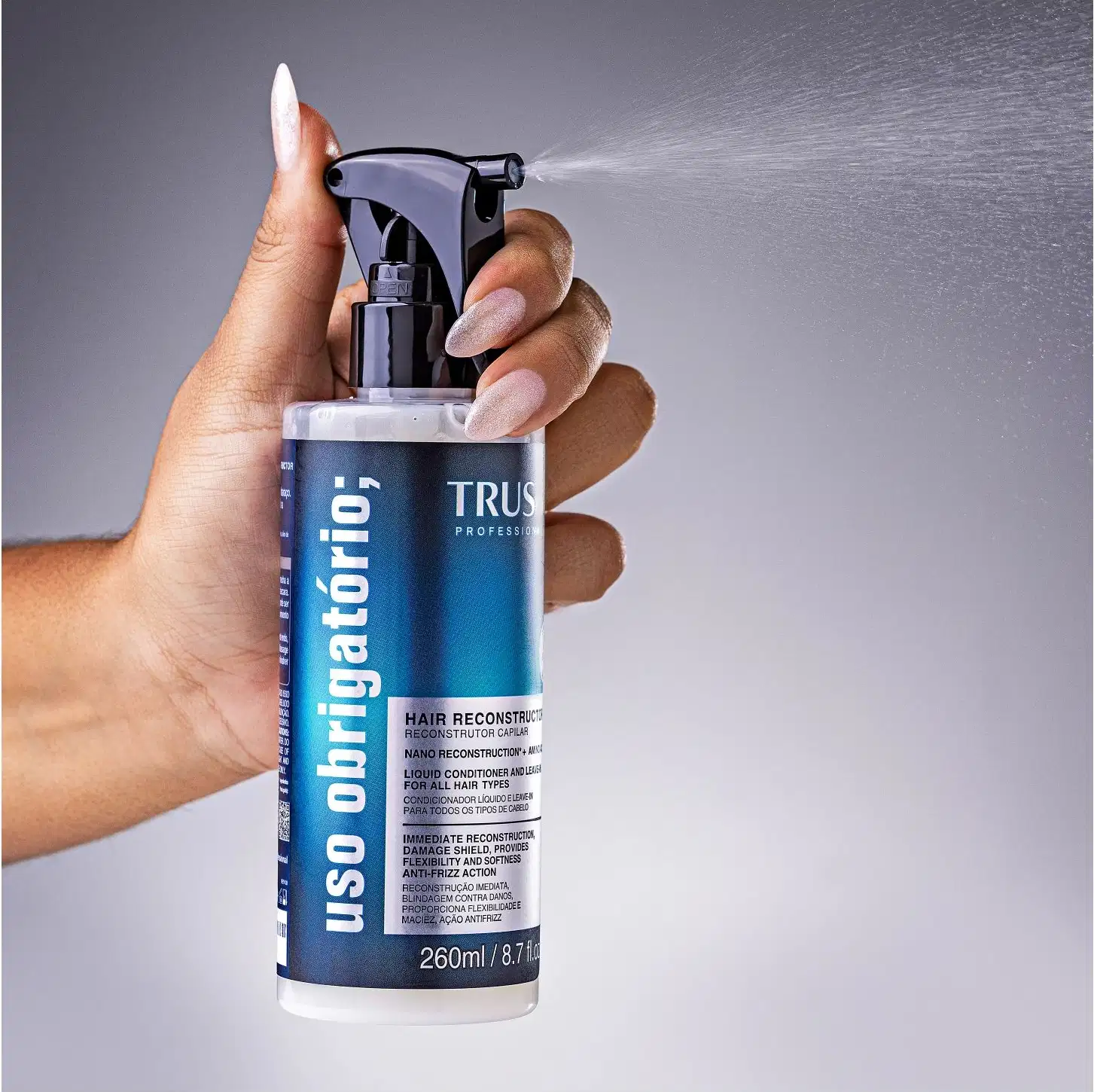 Produto de reconstrução capilar TRUSS Professional. Frasco plástico transparente com spray acionado por gatilho preto. Rótulo azul e preto com texto descrevendo o produto como "Hair Reconstructor" (Reconstrutor Capilar).