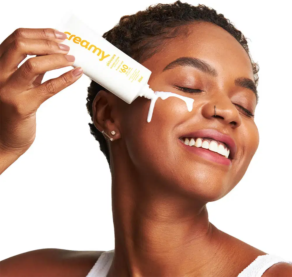 A imagem mostra uma mulher usando o produto no rosto.