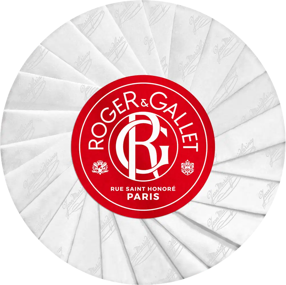 Embalagem circular branca com logotipo vermelho da marca Roger & Gallet, localizada na Rue Saint Honoré em Paris. O design é simples e elegante, com uma aparência premium e sofisticada.