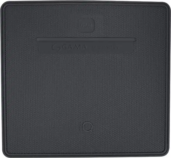 A imagem mostra o carregador sem fio/smart pad cinza escuro da marca GA.MA Italy. O dispositivo tem uma superfície texturizada e formato quadrado.