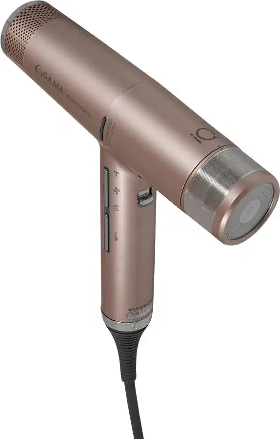 A imagem mostra o secador de cabelo da marca GA.MA Italy. Ele possui o corpo rose gold com detalhes metálicos prateados. Possui um bocal arredondado com aberturas de ventilação. O cabo é ergonômico com botões de controle de temperatura e velocidade.