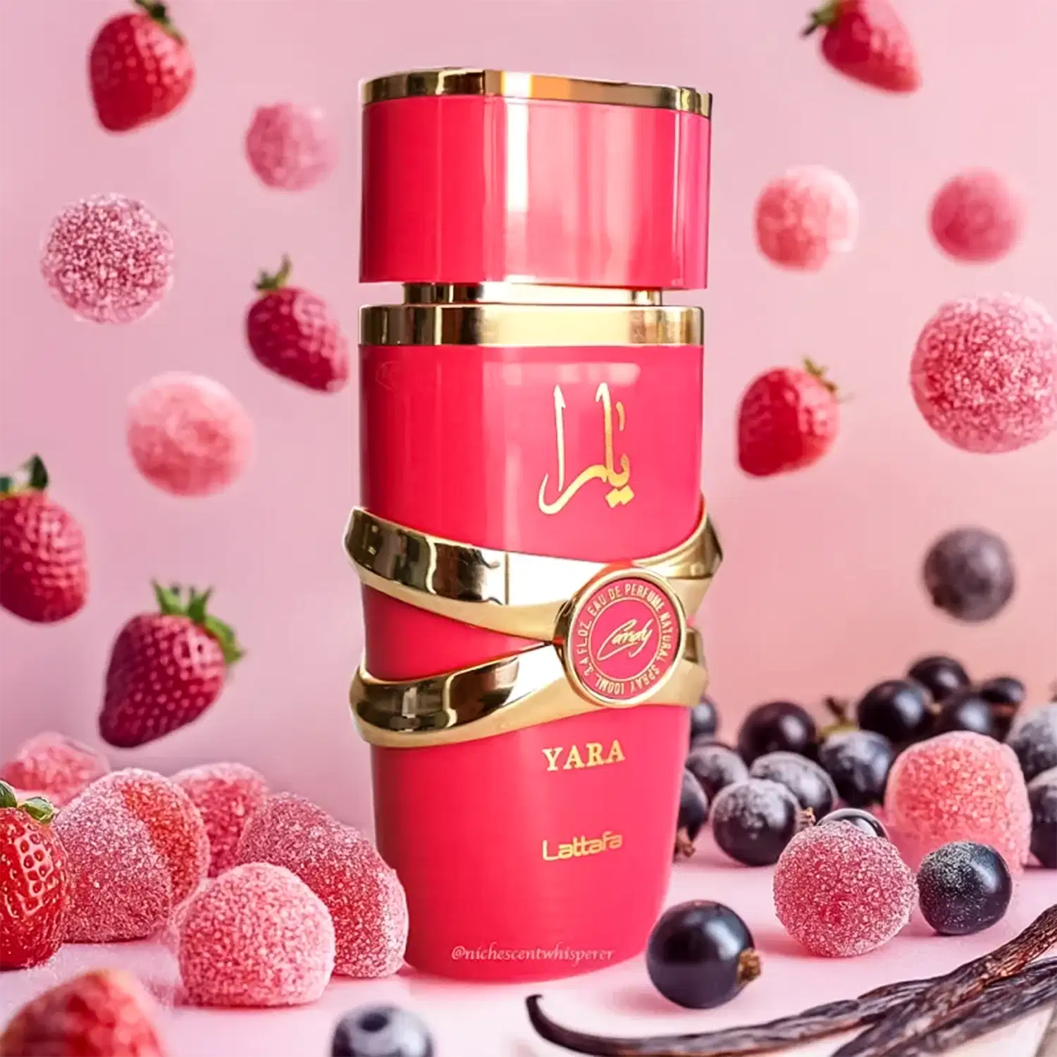 Ambiente de fragrância Lattafa Perfumes Yara, com embalagem vermelha e dourada, cercada por frutas vermelhas e azuis, em um cenário rosa, sugerindo uma ocasião sofisticada e elegante.