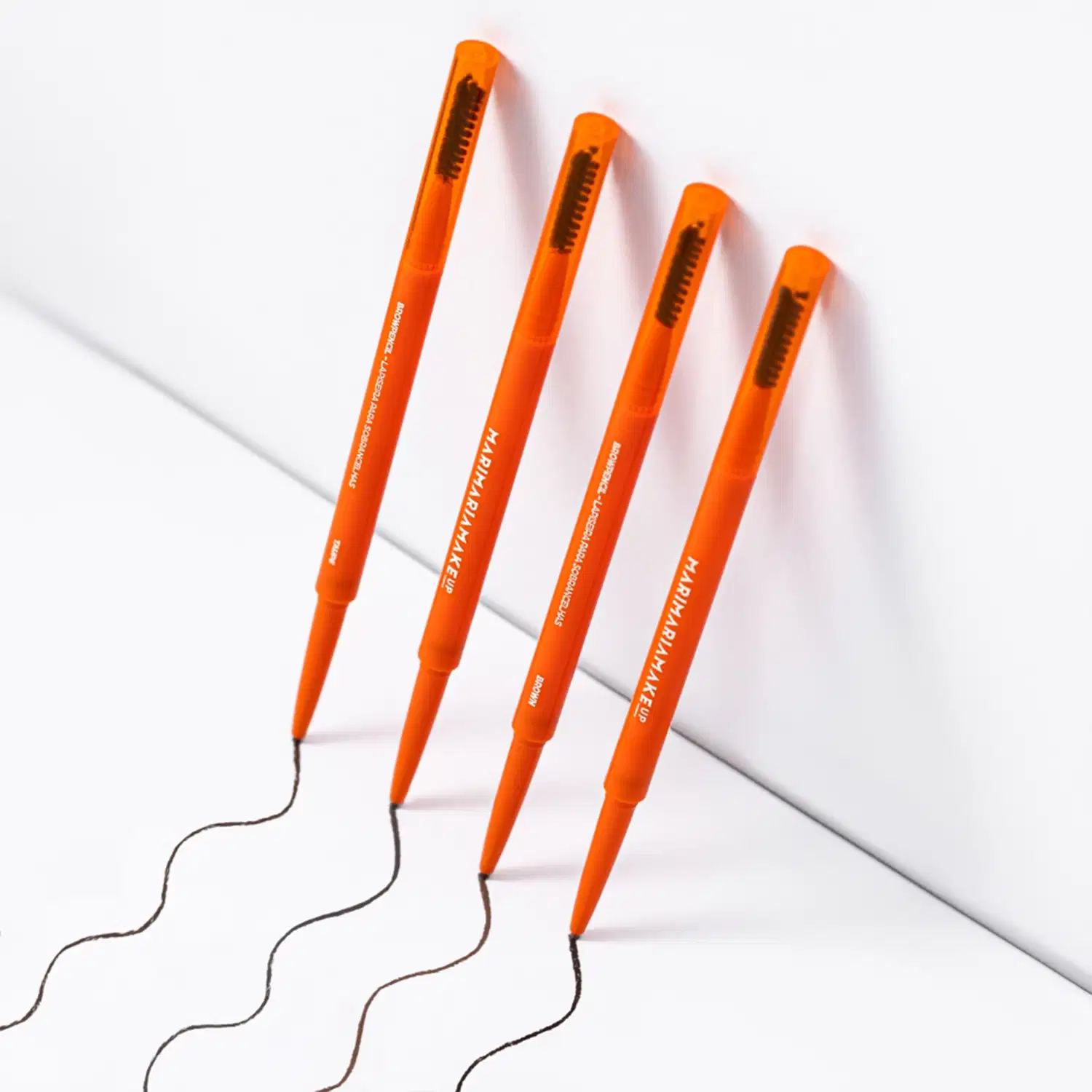 Brow Pencil Mari Maria Makeup em embalagem laranja com detalhes em amarelo. Produto apresenta lápis retratil com ponta fina e escova integrada. Peso: 0,1g. Design ergonômico em tom laranja vibrante.