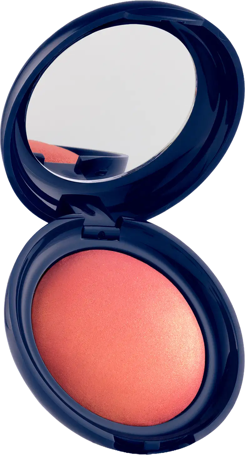 Blush em pó com embalagem redonda azul-marinho, espelho integrado na tampa e produto em tom coral com acabamento luminoso.