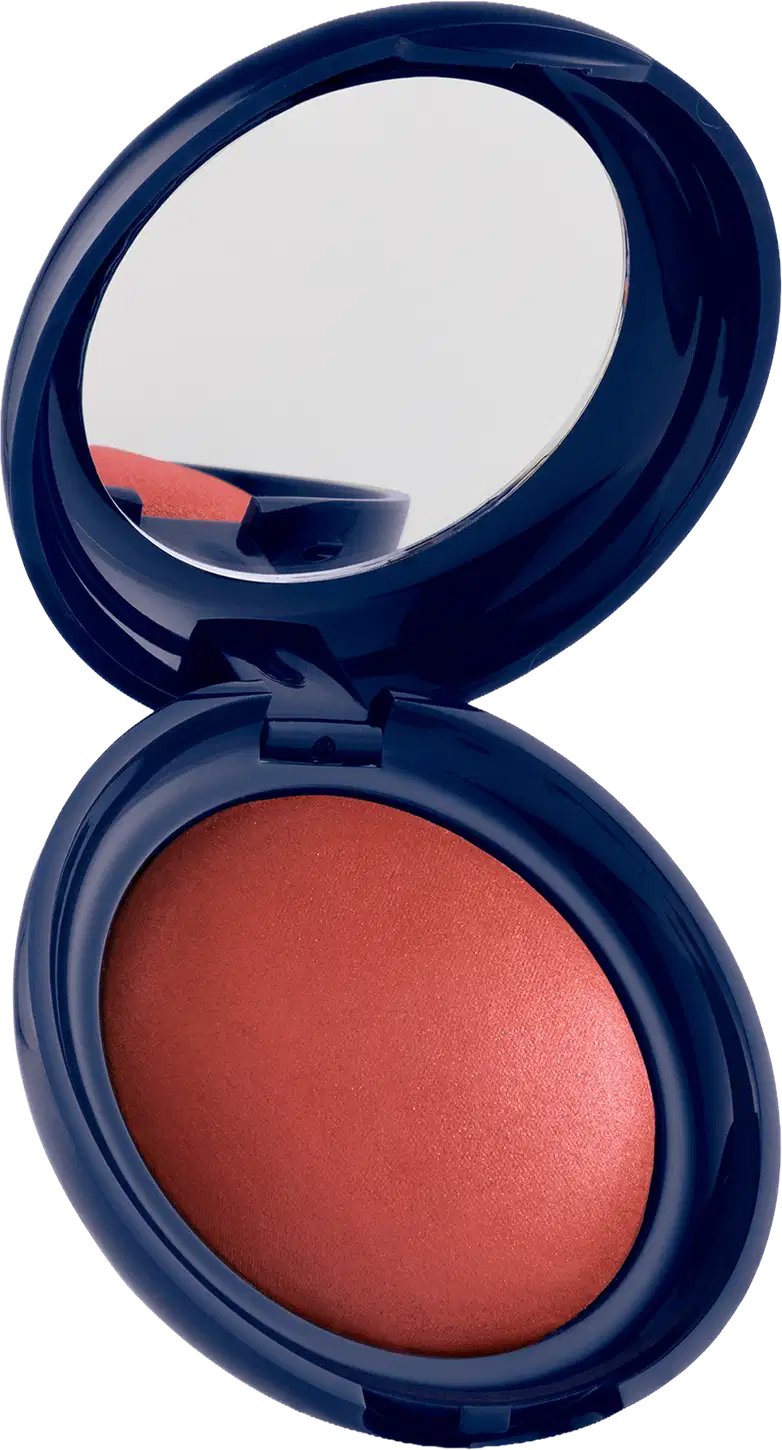 Blush em pó com embalagem redonda azul-marinho, espelho integrado na tampa e produto em tom laranja-avermelhado com acabamento luminoso.