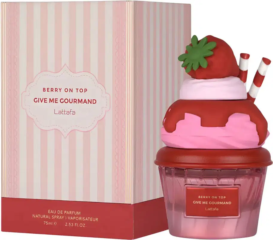 Frasco de perfume em formato de cupcake vermelho e rosa, com tampa em formato de morango verde. Rótulo indica o nome "Berry on Top Give Me Gourmand" da marca Lattafa.