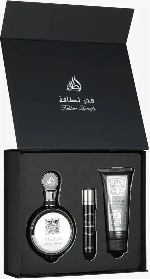 Conjunto de produtos de beleza da marca Lattafa Perfumes, composto por um frasco de perfume, um travel size e um gel de banho em embalagem preta com detalhes em prata e texto em árabe.