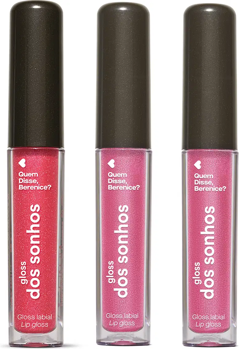 Três frascos de gloss labial da marca Gloss dos Sonhos Quem Disse, Berenice? em tons de rosa, embalagens transparentes  mostrando a cor do item, tampas pretas e rótulos exibindo o nome da marca. Cada um deles conta com 4ml do produto.