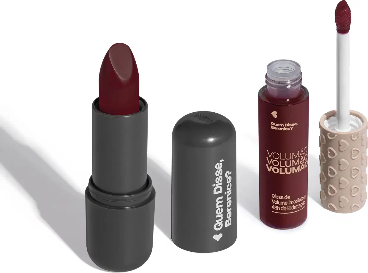 Batom na cor vinho com embalagem cinza e letras brancas e gloss labial de volume imediato Volumão em embalagem transparente e conteúdo na cor cereja com tampa cinza e aplicador vermelho escuro. Ambos da marca Quem Disse, Berenice?.