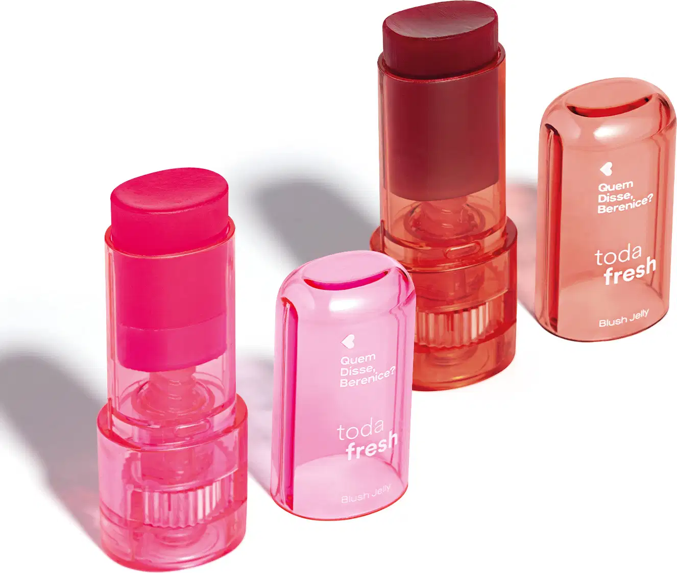 Produtos de maquiagem da marca Quem Disse, Berenice? em embalagens plásticas translúcidas nas cores rosa e vermelho, incluindo um batom, um blush em bastão e um produto de acabamento.