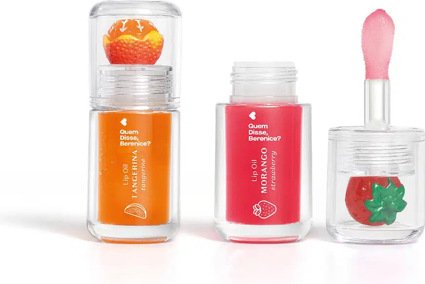 Imagem do Combo Lip Oil Quem Disse Berenice? com um produto na cor Vermelho Morango, em tonalidade vermelha e morango decorando a tampa e e outro na cor Coral Tangerina em tonalidade laranja com uma tangerina de decoração. As embalagens são transparentes.