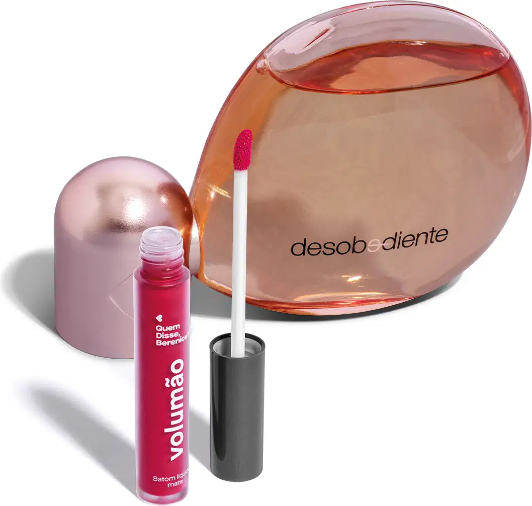 Frasco de perfume Desobediente da marca Quem Disse, Berenice? com tampa rosada e líquido vermelho, acompanhado de um batom líquido da mesma marca na cor rosa.