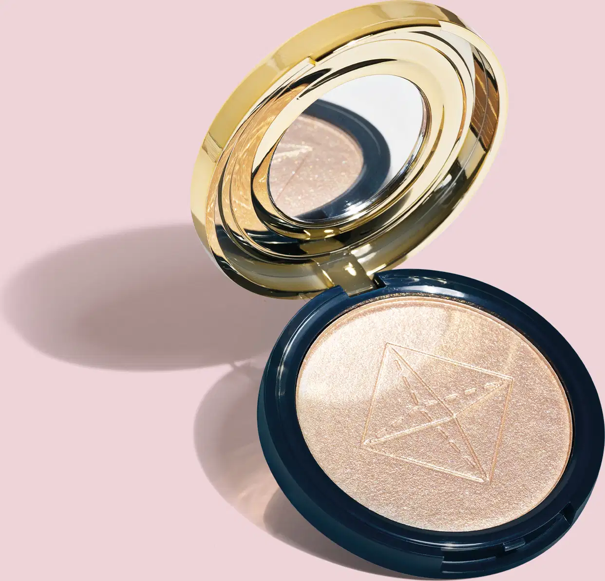 Produto de maquiagem em pó compacto com acabamento iluminado. Embalagem redonda azul com tampa dourada espelhada em camadas concêntricas. O pó compacto apresenta um acabamento perolado dourado. O design da embalagem dourado luxuoso contrasta com o azul.