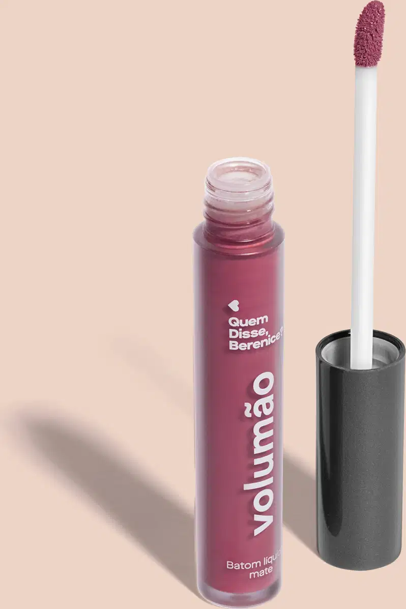Tubo de batom líquido Volumão Roxo Ameixali Quem Disse, Berenice? em frasco com líquido roxo, tampa preta, haste branca e esponja roxa, tudo em fundo lilás.