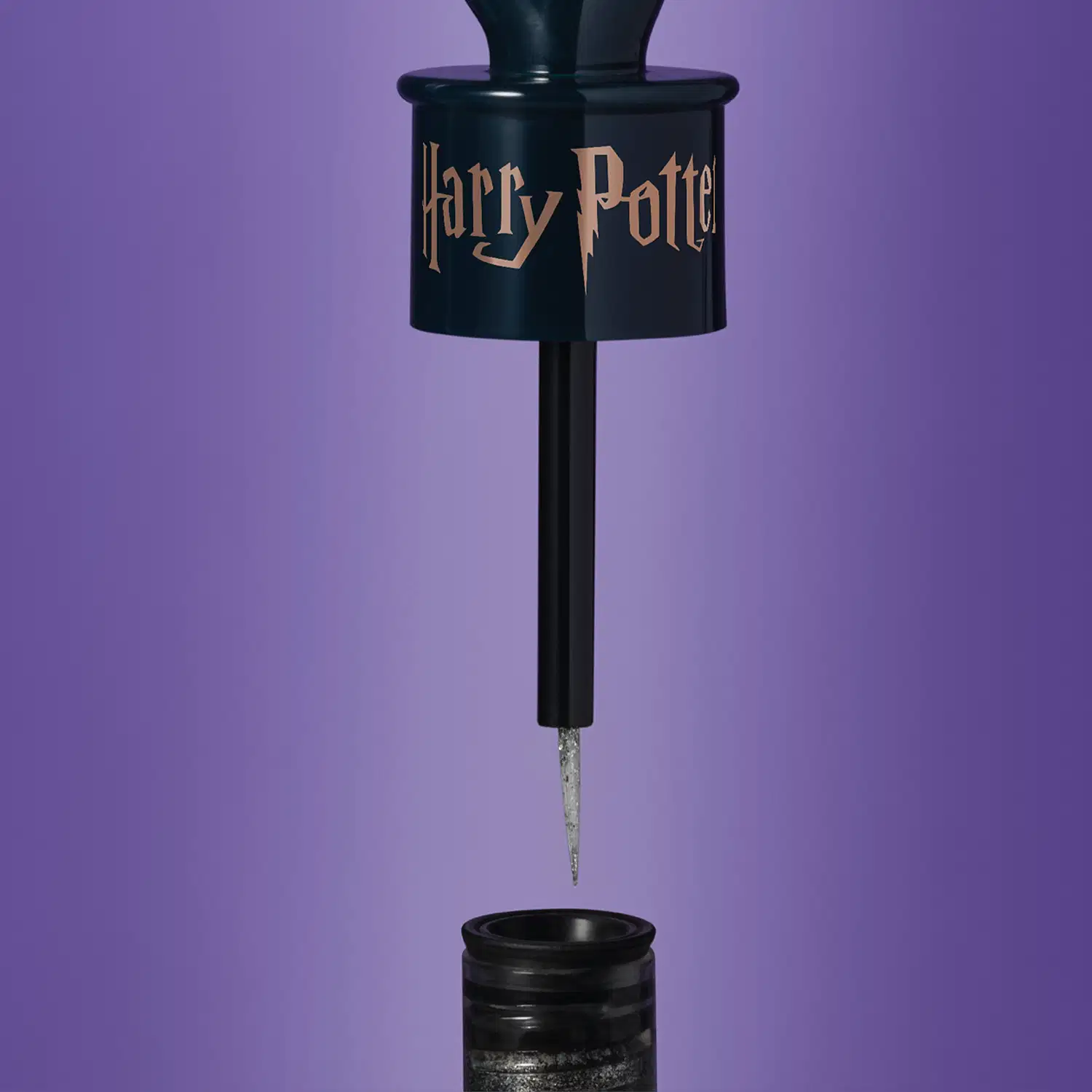 Tampa preta com o nome Harry Potter gravado em letras douradas e ponta prateada em fundo azul escuro.