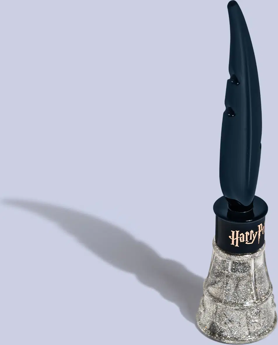 Frasco com formato alongado e curvilíneo. A parte inferior é prata com brilhos. O frasco tem um aplicador em forma de pena alongada na parte superior, na cor azul. Na base da tampa, a logo "Harry Potter" em letras estilizadas na cor prata brilhante.