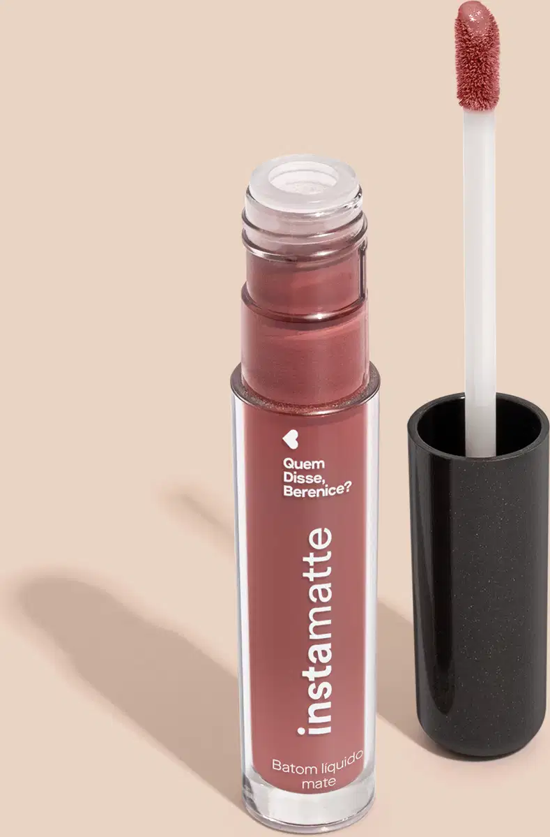 Frasco cilíndrico transparente com letras brancas contendo 4ml de batom líquido marrom Castanheli Instamatte Quem Disse Berenice?. A tampa do produto é preta e traz haste branca e esponja aplicadora na cor do produto.
