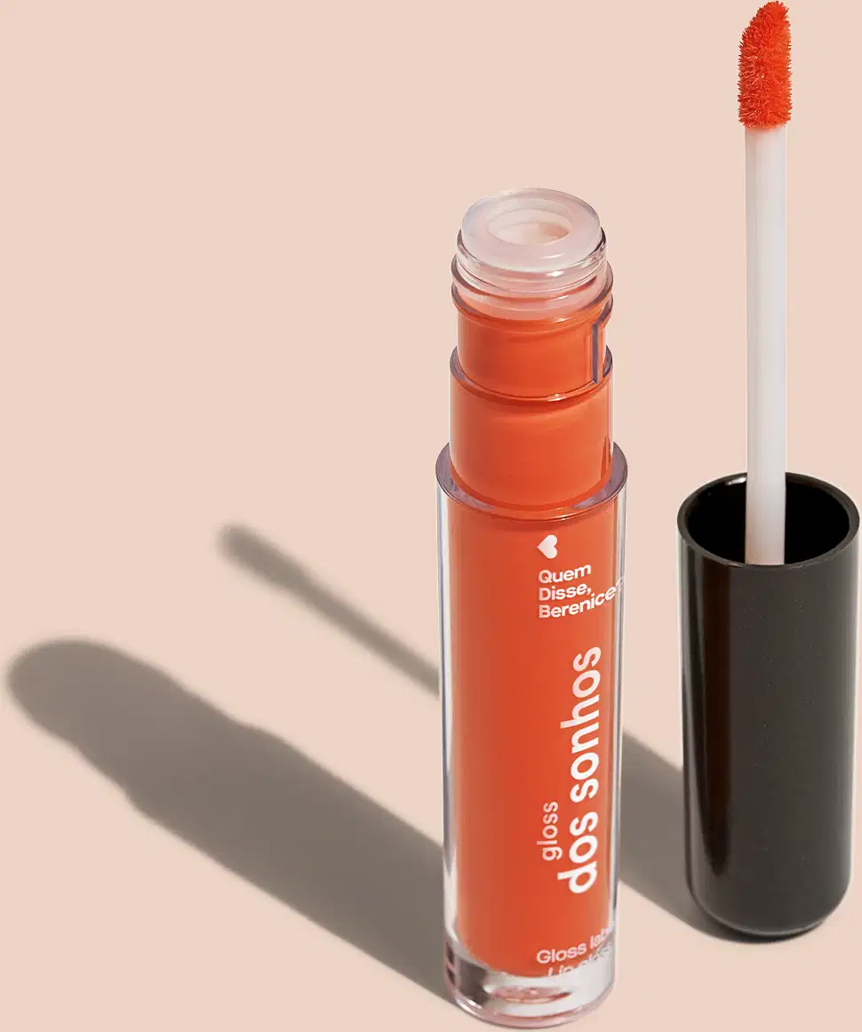 Batom líquido coral Coraldex dos Sonhos Quem Disse, Berenice? em tubo cilíndrico transparente mostrando a tonalidade do produto e tampa preta em fundo lilás.