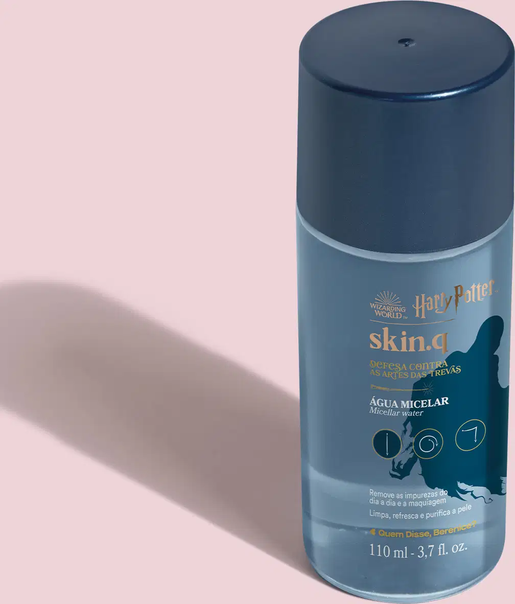 O frasco contém um produto líquido chamado "Skin.q Água Micelar" da linha Harry Potter. A embalagem apresenta detalhes em tons de azul claro e branco, incluindo o logotipo da marca Harry Potter, o nome do produto "Defesa Contra a Arte das Trevas."
