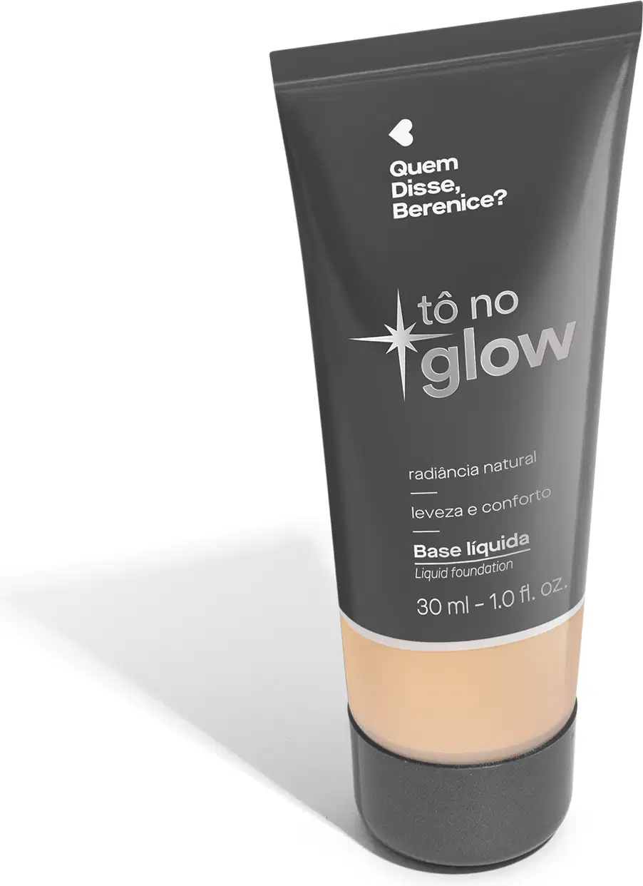O produto apresentado é uma base líquida da marca Tô no Glow, com embalagem em tubo plástico de cor cinza escura. O rótulo exibe o nome da marca e o texto "Radiância natural, leveza e conforto" em letras brancas.