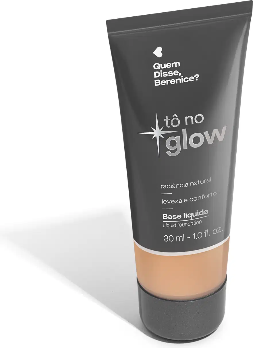 O produto apresentado é uma base líquida da marca Tô no Glow, com embalagem em tubo plástico de cor cinza escura. O rótulo exibe o nome da marca e o texto "Radiância natural, leveza e conforto" em letras brancas.