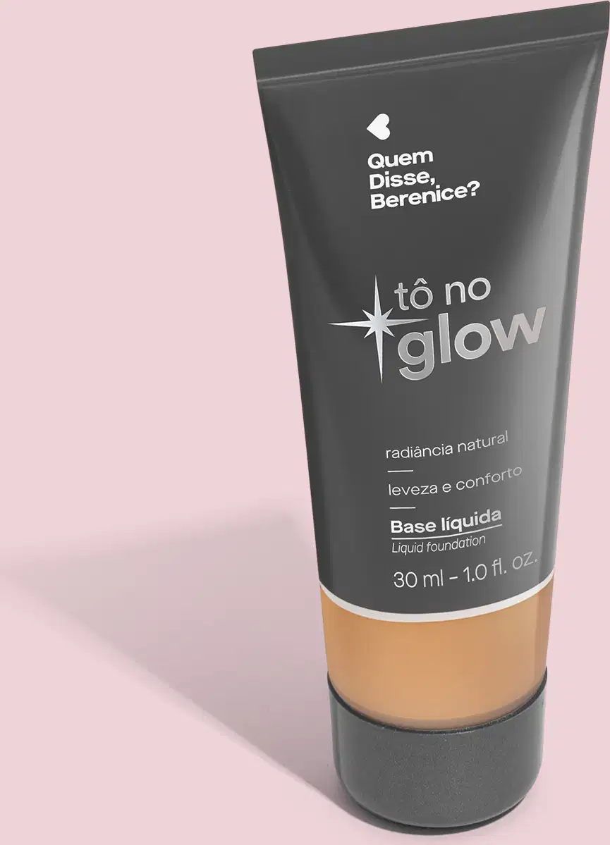 Base líquida em bisnaga preta com base transparente onde é possível ver o tom do produto. Fundo rosa.