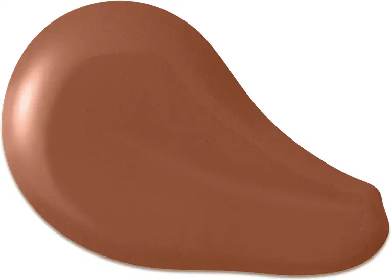 O produto apresentado na imagem é uma base de maquiagem de cor marrom escuro, com uma textura cremosa e suave. Sua forma é arredondada e convexa. Não há rótulos, marcas ou outras informações visíveis na imagem.