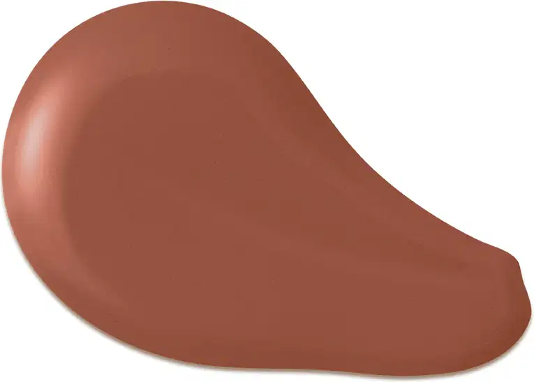 O produto apresentado na imagem é uma base de maquiagem de cor marrom escuro, com uma textura cremosa e suave. Sua forma é arredondada e convexa. Não há rótulos, marcas ou outras informações visíveis na imagem.