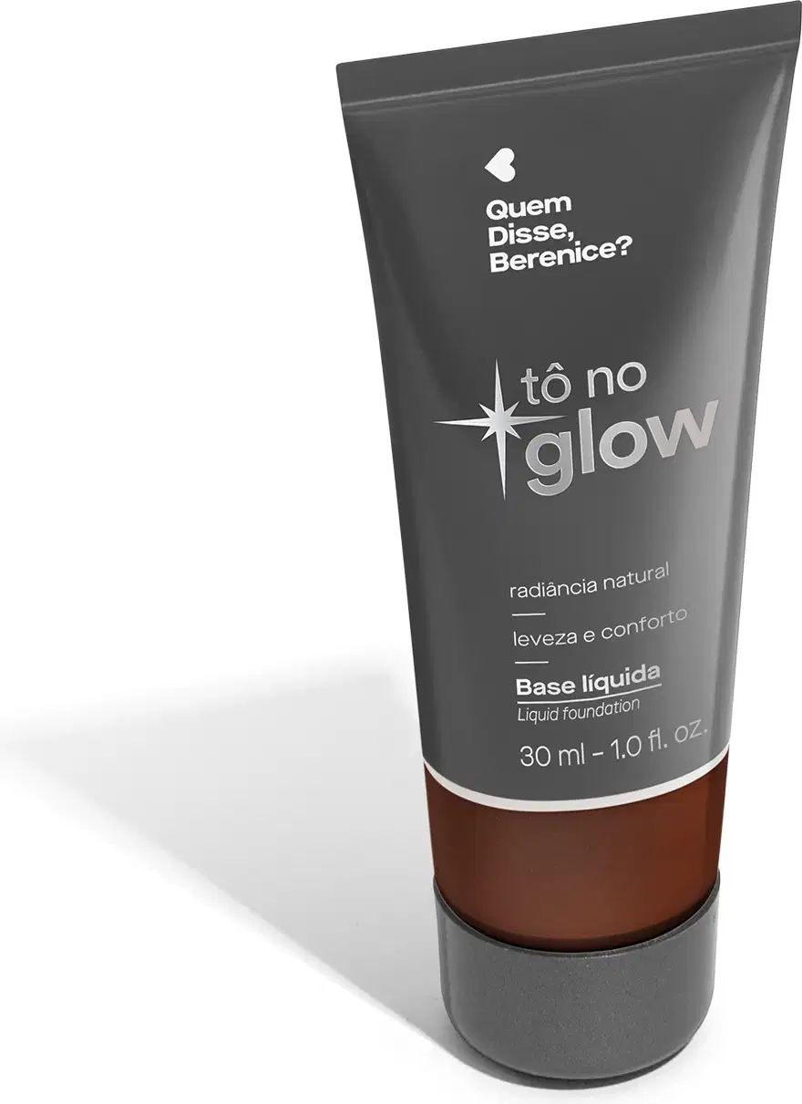O produto apresentado é uma base líquida da marca Tô no Glow, com embalagem em tubo plástico de cor cinza escura. O rótulo exibe o nome da marca e o texto "Radiância natural, leveza e conforto" em letras brancas.