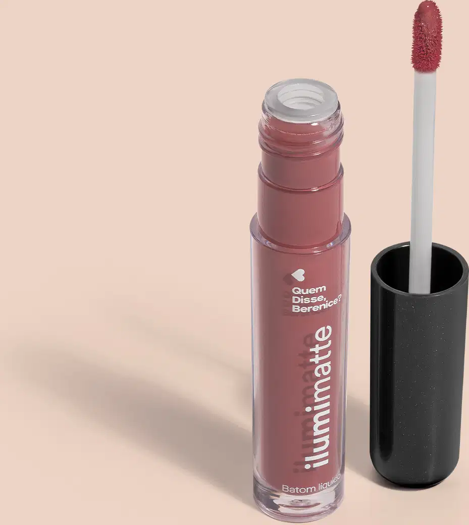 Frasco de batom líquido rosa Rosalumi Ilumimatte Quem Disse, Berenice? aberto, mostrando a tonalidade do produto,, com a tampa preta ao lado que traz haste branca e esponja aplicadora na cor rosa em fundo rosado com leve sombreado.
