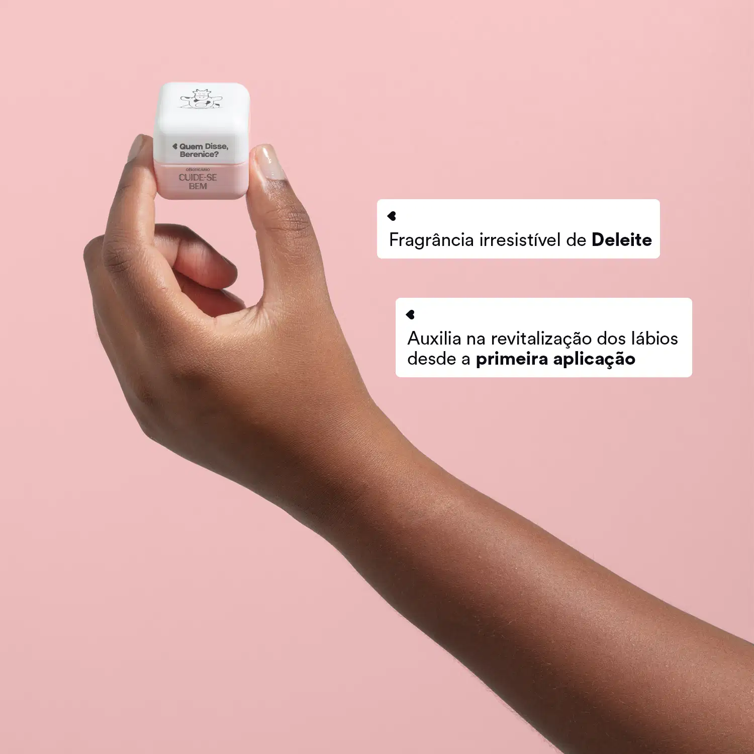 O produto é um hidratante labial da marca Quem Disse, Berenice?. Apresenta uma embalagem pequena e quadrada de cor branca. Há textos sobre ser uma "Fragrância irresistível de Deleite" .A imagem mostra uma mão segurando o produto sobre um fundo rosa claro.