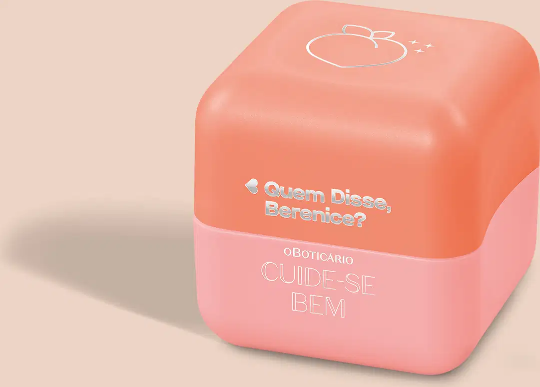 Balm labial em embalagem plástica hexagonal na cor coral. A parte superior da embalagem é mais escura, com um desenho estilizado de um pêssego. Na parte inferior, texto em letras brancas: "Quem Disse, Berenice? OBOTICÁRIO CUIDE-SE BEM".