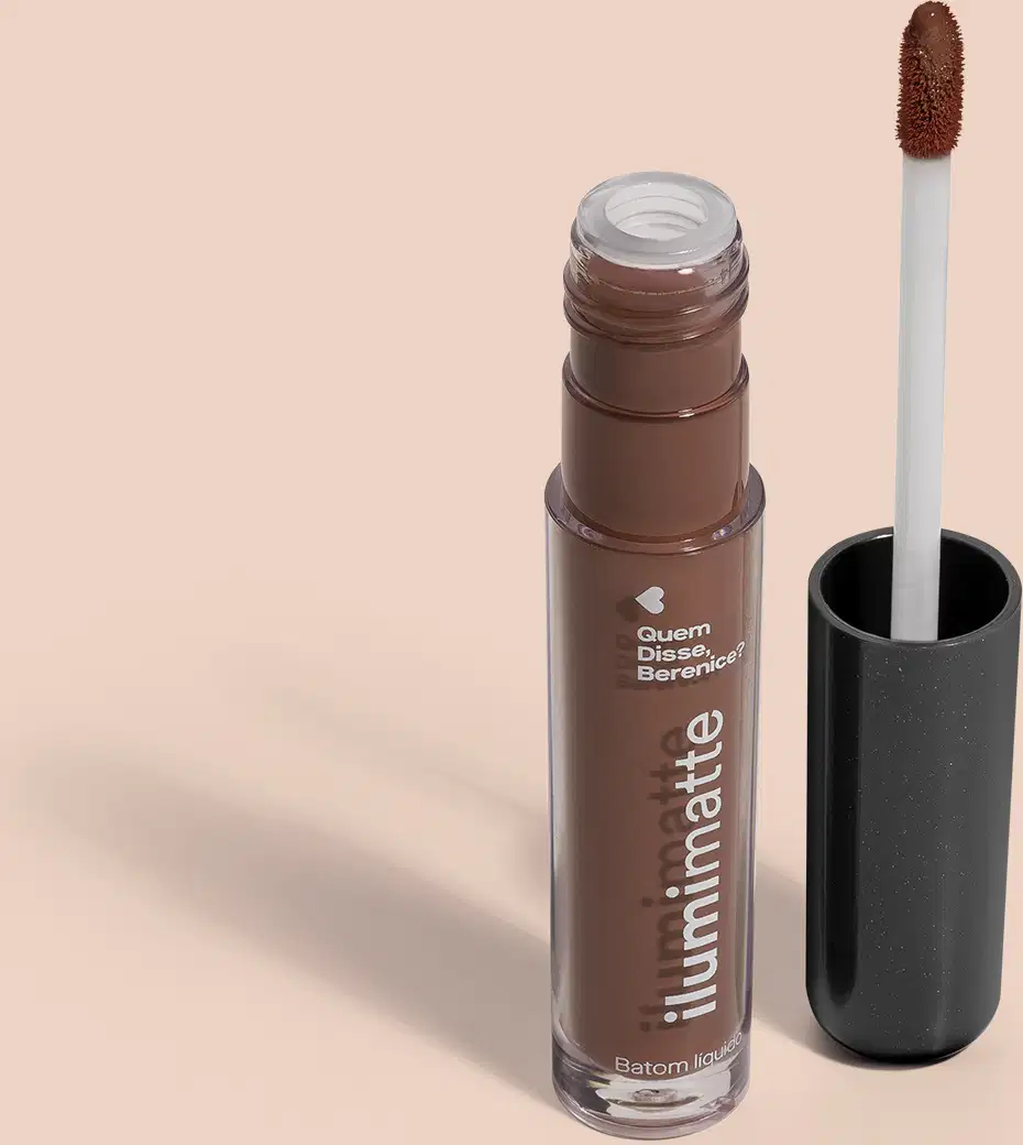 Frasco de batom líquido marrom Marronlumi Ilumimatte Quem Disse, Berenice? aberto, mostrando a tonalidade do produto,, com a tampa preta ao lado que traz haste branca e esponja aplicadora na cor marrom em fundo rosado com leve sombreado.
