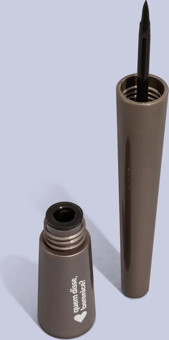 Produto de beleza em embalagem metálica cinza escuro, um frasco e um lápis. O frasco possui um rótulo com um coração, uma ponta preta e uma extremidade oca.