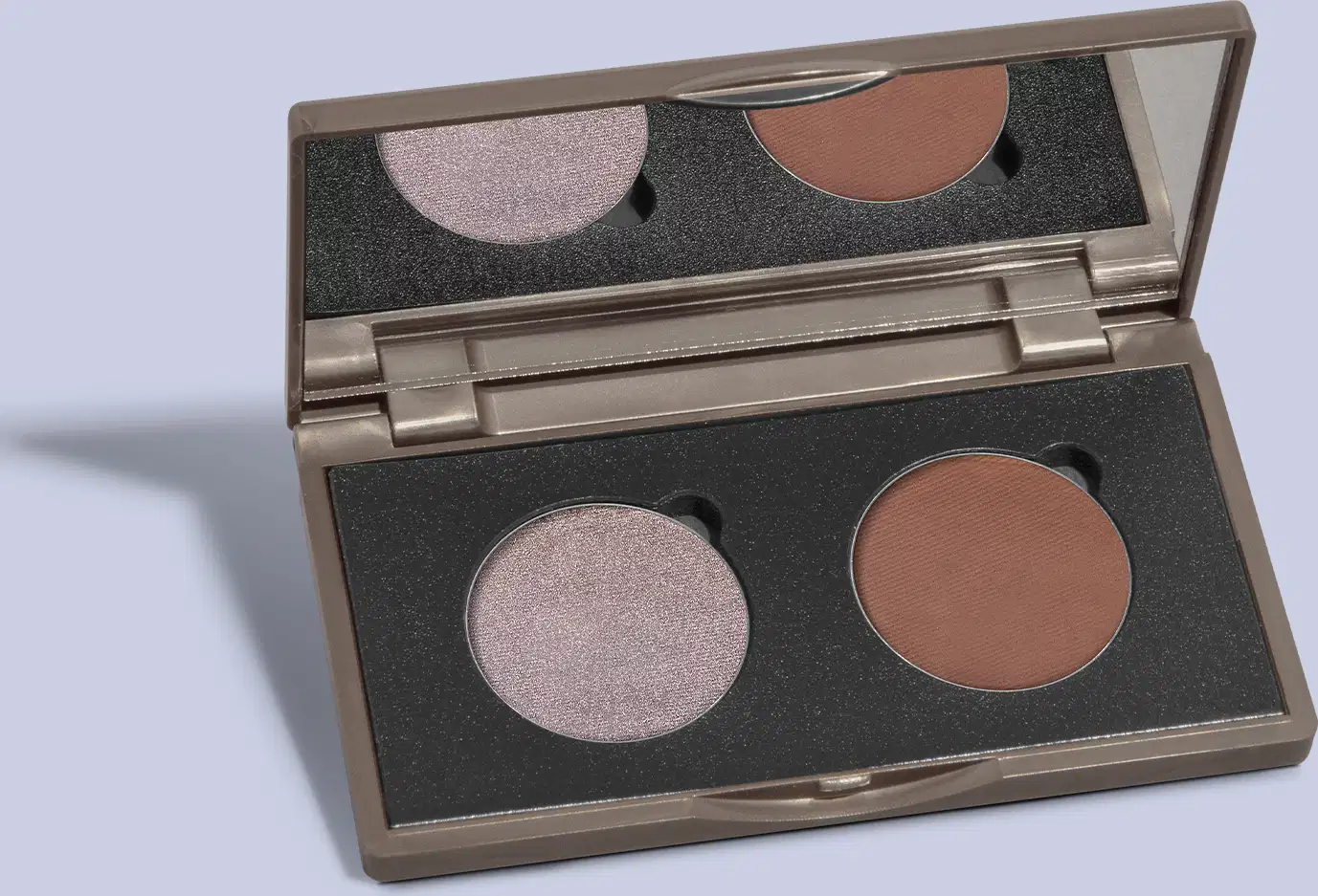 O produto de beleza apresentado na imagem é uma paleta de maquiagem da marca Quem Disse, Berenice? A paleta possui uma embalagem retangular de plástico preto com detalhes em dourado. Dentro da paleta, há dois sombras circulares.