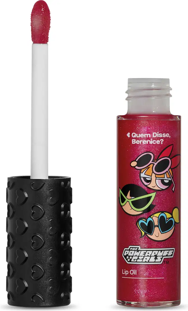 Frasco de lip oil na cor rosa da marca Meninas Superpoderosas Quem Disse, Berenice? em embalagem transparente mostrando a tonalidade do produto, tampa preta com haste e esponjinha vermelha, mostrando ilustração de personagens, contendo 9,5ml.