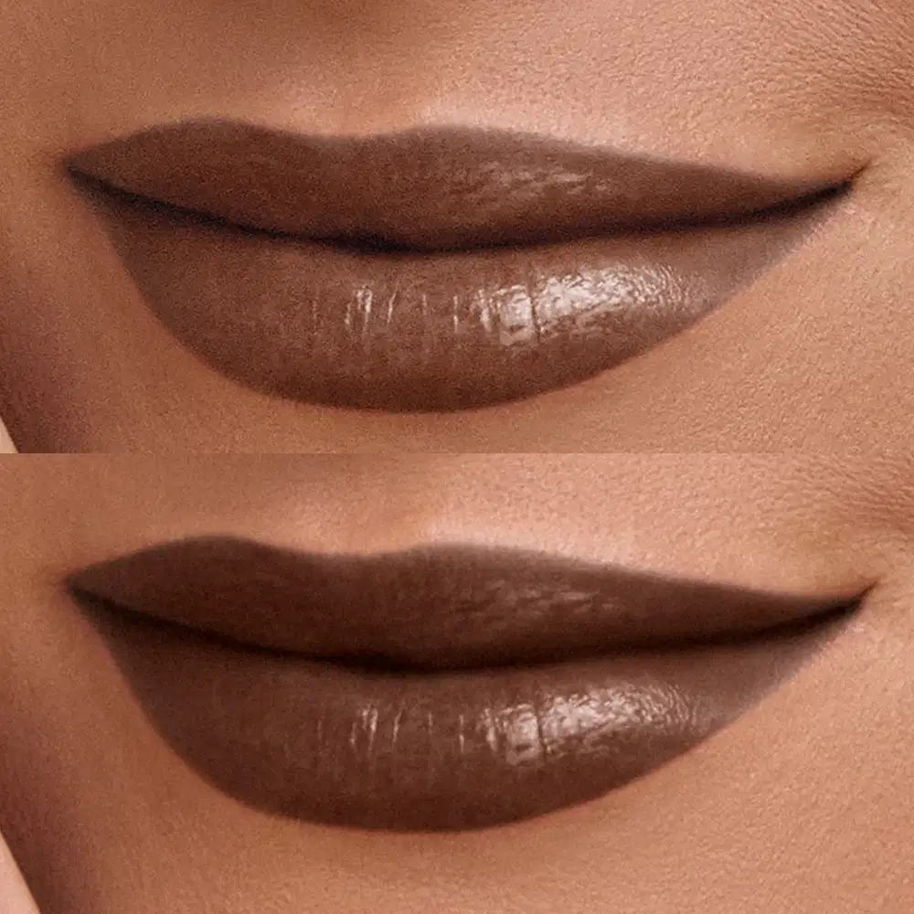 A imagem mostra os lábios de uma pessoa com uma maquiagem escura e marcante, provavelmente um produto de beleza da marca. O foco está na aplicação do produto, destacando a textura e o acabamento escuro e intenso.