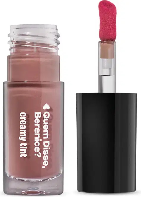 Frasco de gloss labial da marca Quem Disse, Berenice? na cor rosa escuro, com aplicador de pincel vermelho. Embalagem preta com texto branco indicando o nome do produto "Creamy tint".