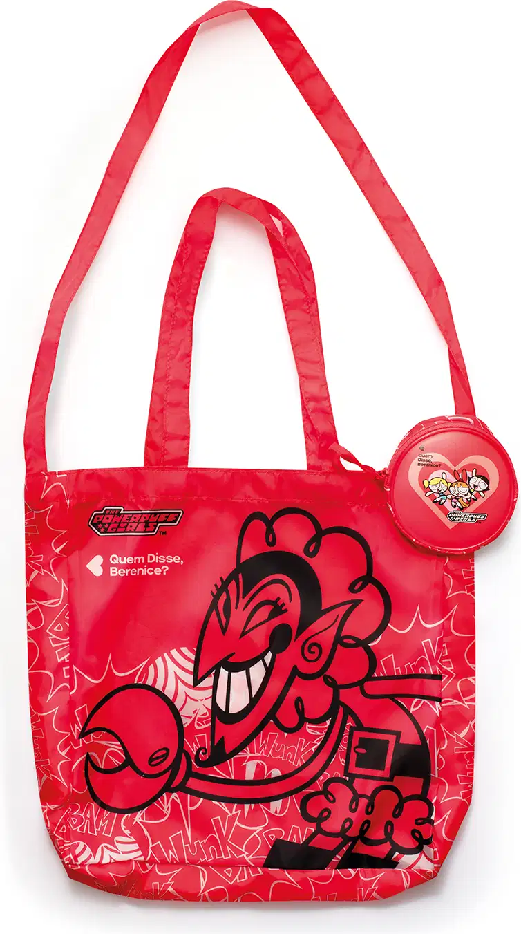 Bolsa vermelha com estampa das Meninas Superpoderosas, contendo um acessório redondo com o mesmo design. A bolsa possui alças longas e um texto em destaque na parte frontal.