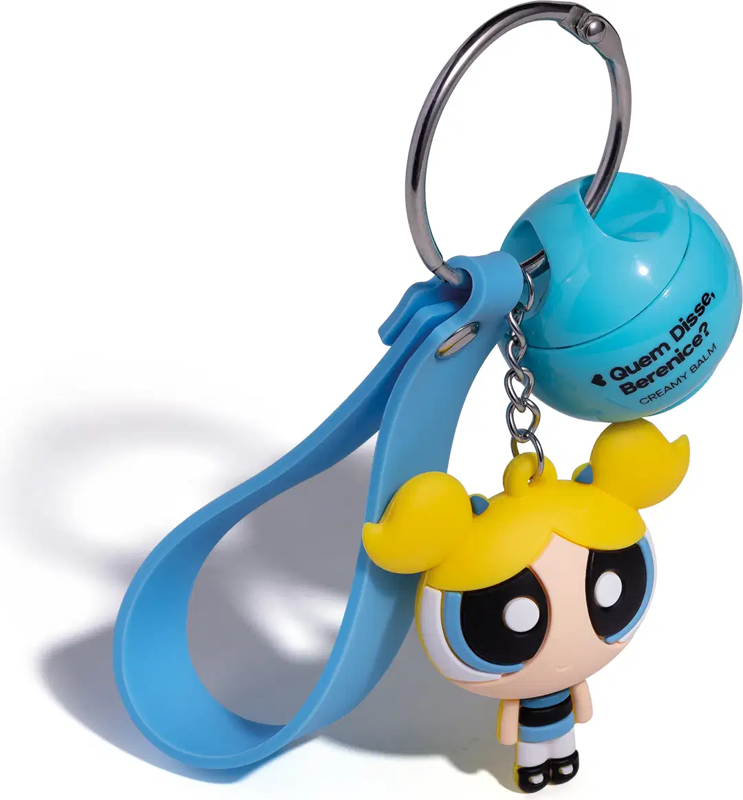 Chaveiro em formato da personagem Florzinha das Meninas Superpoderosas, com vestido azul e cabelo amarelo, preso a um produto da marca Quem Disse, Berenice?.