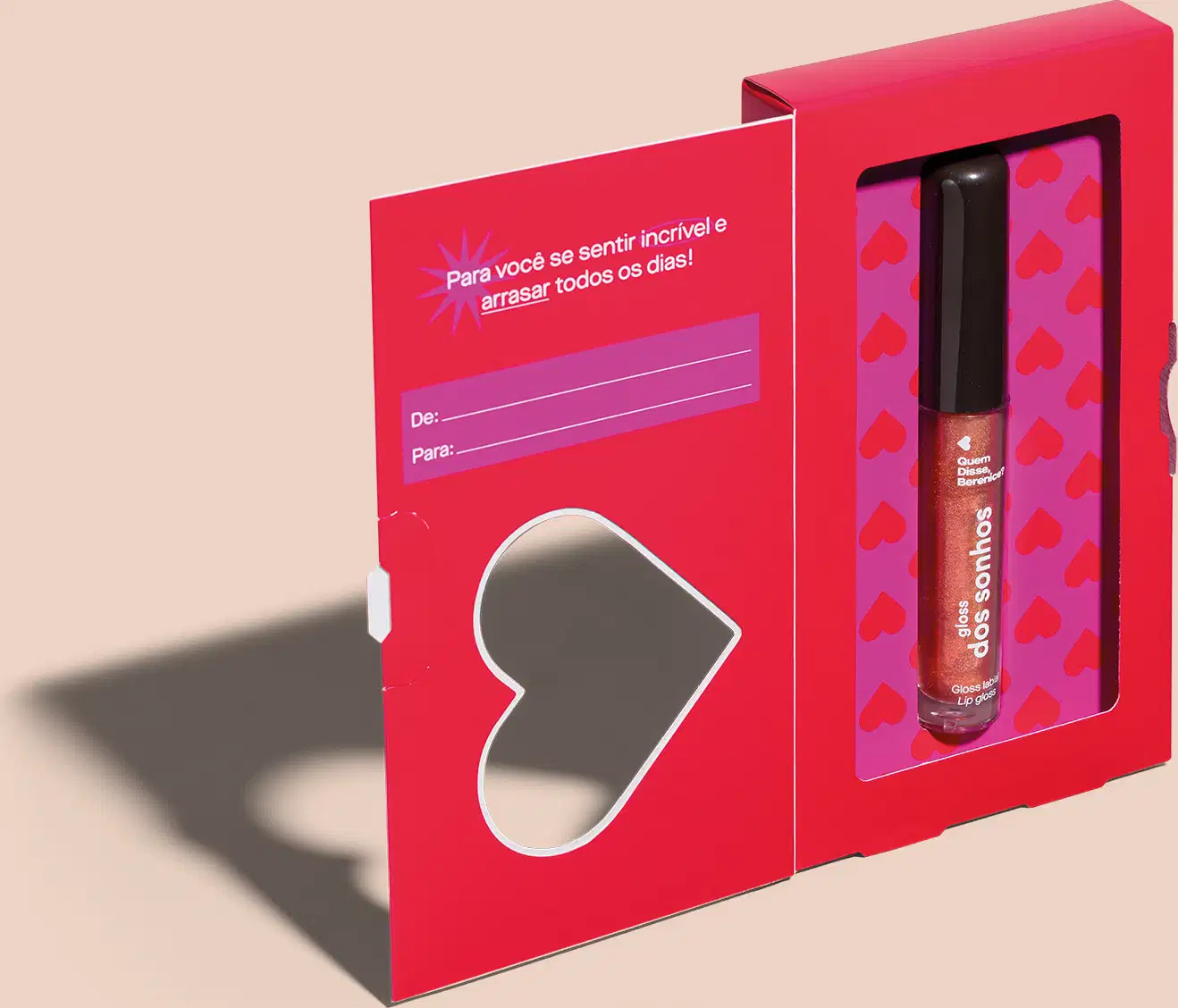 Imagem de uma caixa vermelha presenteável, ilustrada com coração vazado e espaço para dedicatória, acompanhado de um gloss labial marrom avermelhado da marca Quem Disse, Berenice?, com frasco em formato de tubo,  rótulo branco e tampa preta