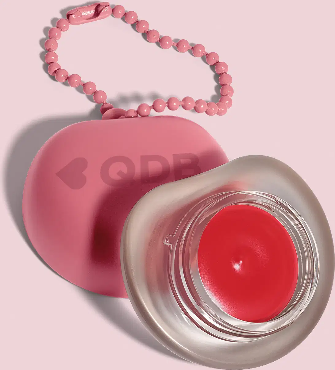Recipiente rosa com logotipo em forma de coração, O recipiente está sobre um fundo rosa. A imagem sugere um ambiente relacionado a produtos de beleza e cuidados pessoais.