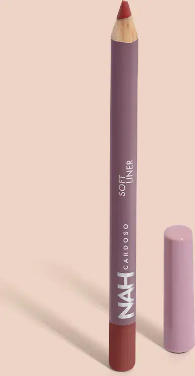 Lápis de maquiagem labial da marca Nah Cardoso, em embalagem roxa com texto em branco. O lápis tem formato cilíndrico e ponta rosa, indicando a cor do produto.