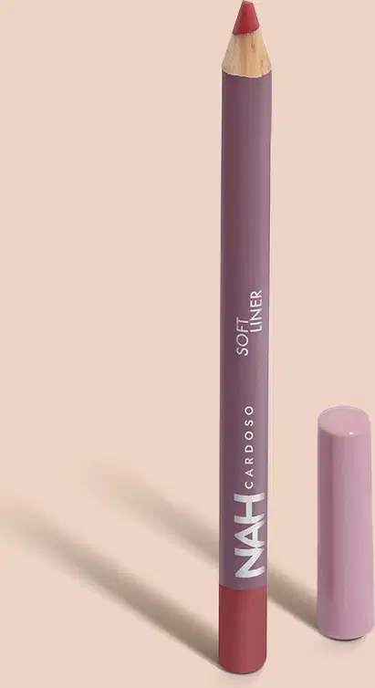 Lápis de boca da marca Nah Cardoso, em embalagem roxa com texto em branco, com ponta marrom visível. O produto possui formato cilíndrico e é um cosmético para aplicação nos lábios.