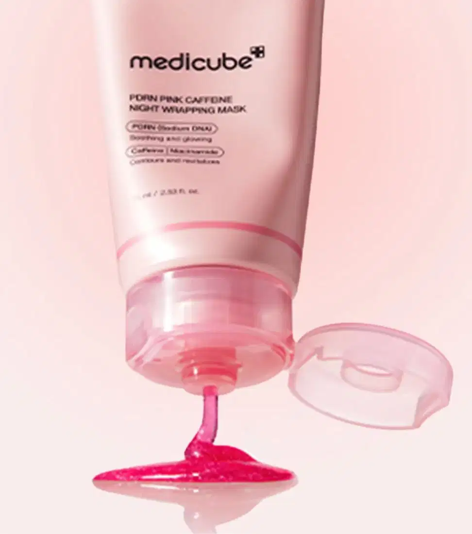Um tubo rosa-claro da Medicube com máscara rosa vibrante escorrendo sobre superfície clara, em fundo rosa suave e minimalista, transmitindo ambiente de cuidado noturno com a pele.