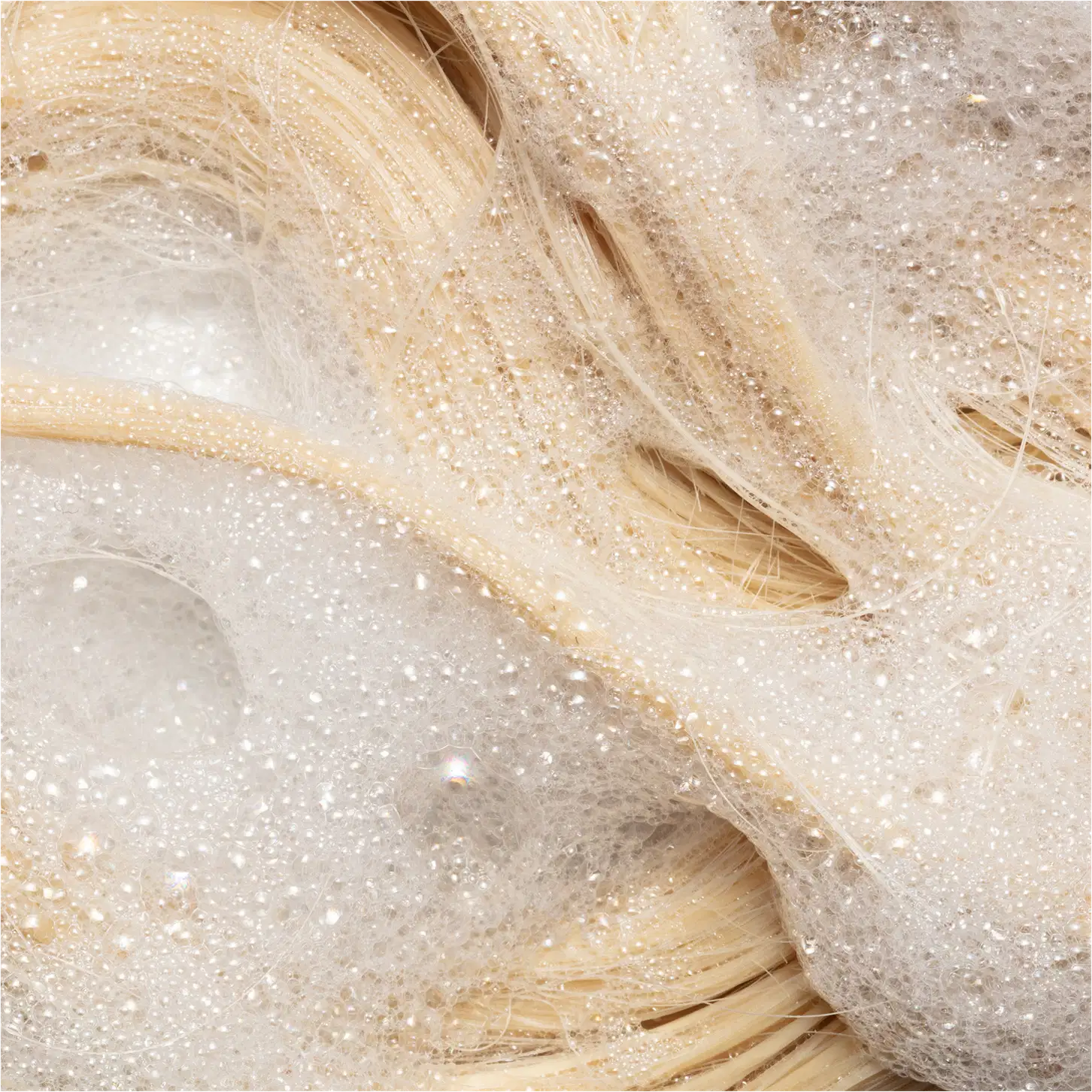 Shampoo da linha Blond Revolution da marca TRUSS. Imagem com cabelos sendo limpos.