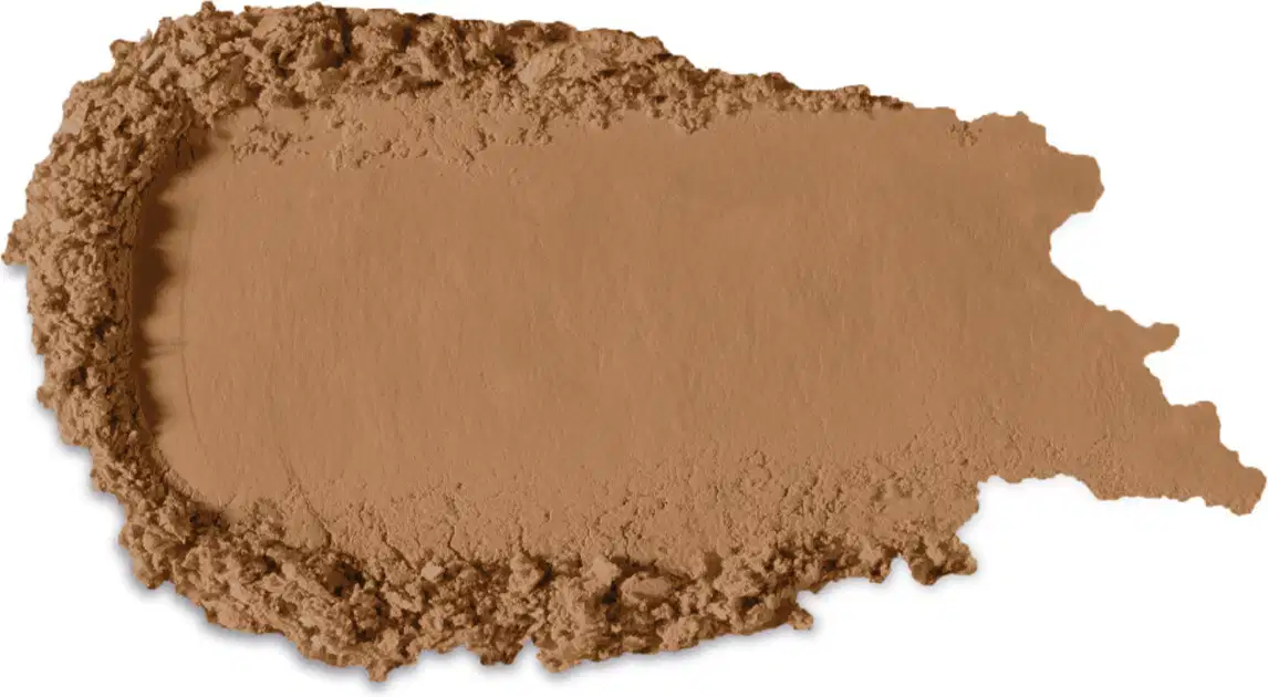 Textura no tom marrom de produto de maquiagem com acabamento aveludado e superfície irregular, com pequenos grânulos visíveis, indicando a textura em pó.
