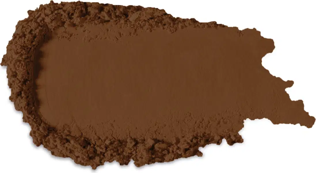 Textura no tom marrom escuro de produto de maquiagem com acabamento aveludado e superfície irregular, com pequenos grânulos visíveis, indicando a textura em pó.
