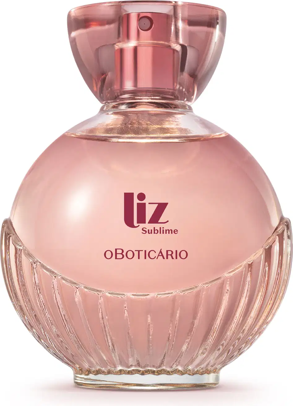 frasco de item de perfumaria da marca Liz Sublime, com embalagem de vidro arredondada rosa-claro facetado e nome da marca em vermelho escuro gravado no vidro. A tampa é em acrílico transparente e permite ver a tampa borrifadora de tom metálico rosa.